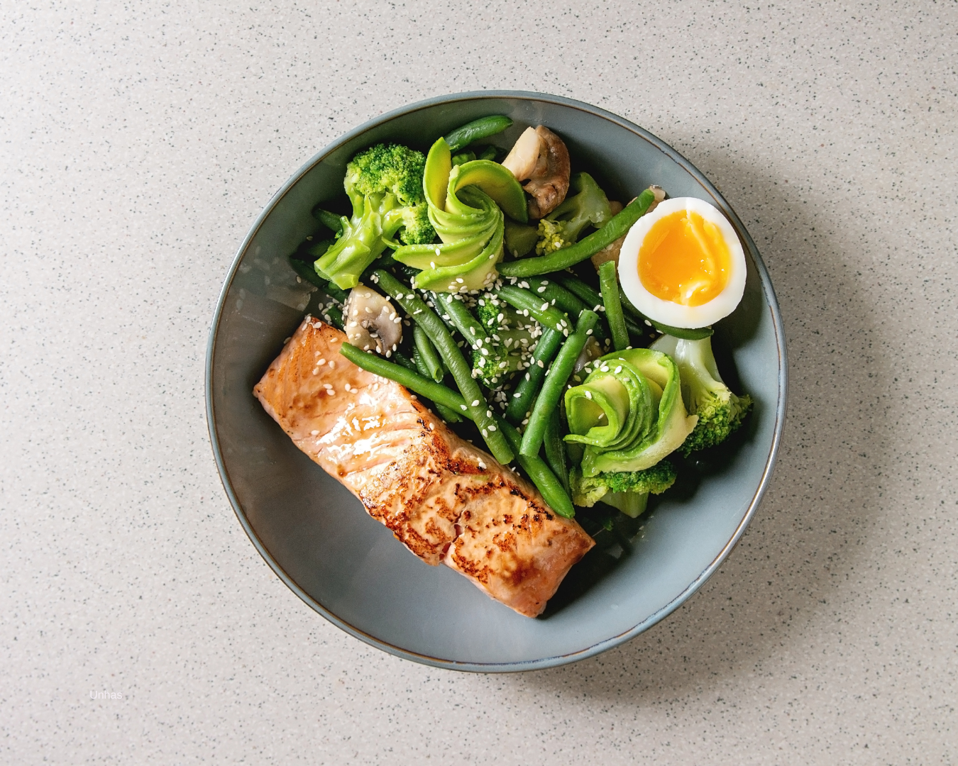 Tigela com ovos, salmão, nozes e verduras representando alimentos para unhas saudáveis em São Paulo.